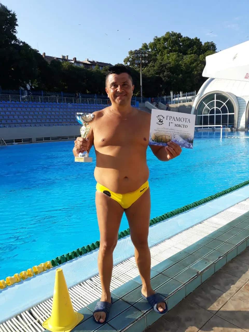 A player with a cup and the first-place certificate