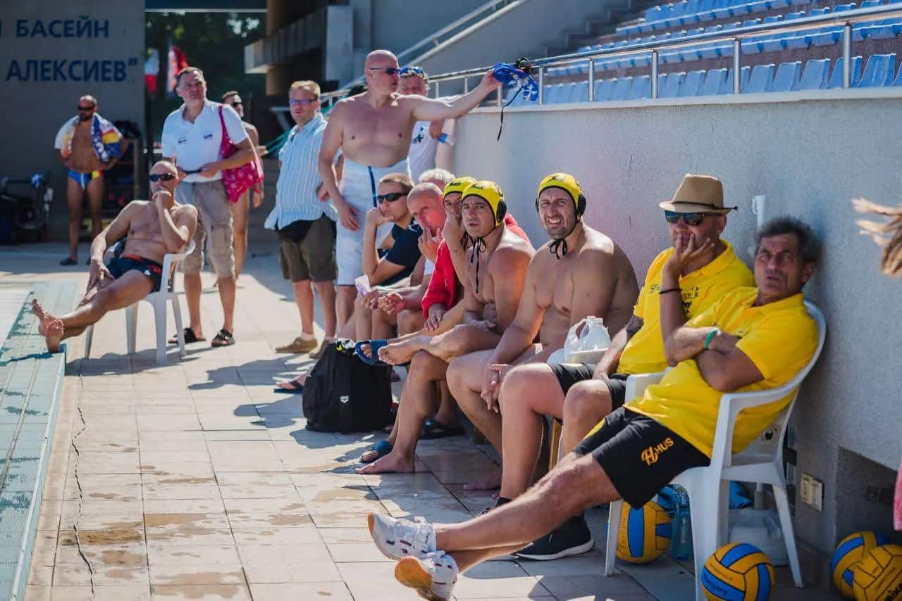 The team and spectators by the pool